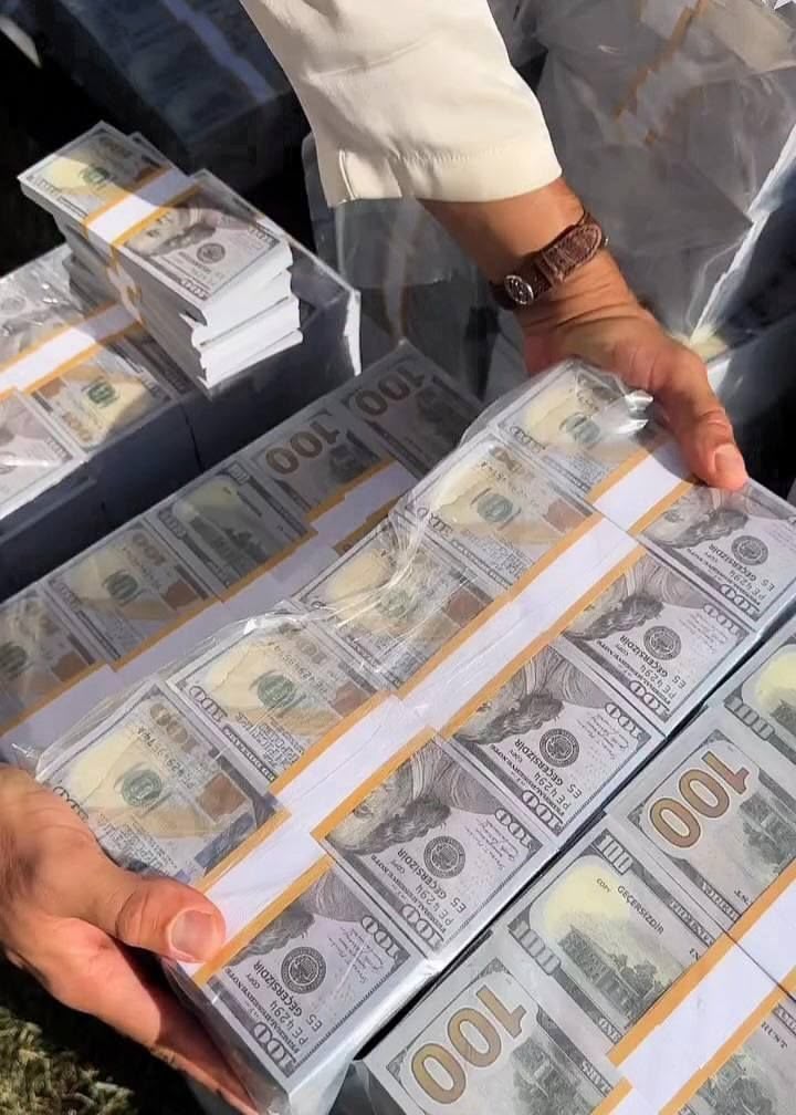 Hands holding wrapped bundles of US dollar banknotes
