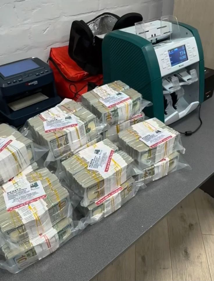 Wrapped banknote bundles beside a money-counting machine